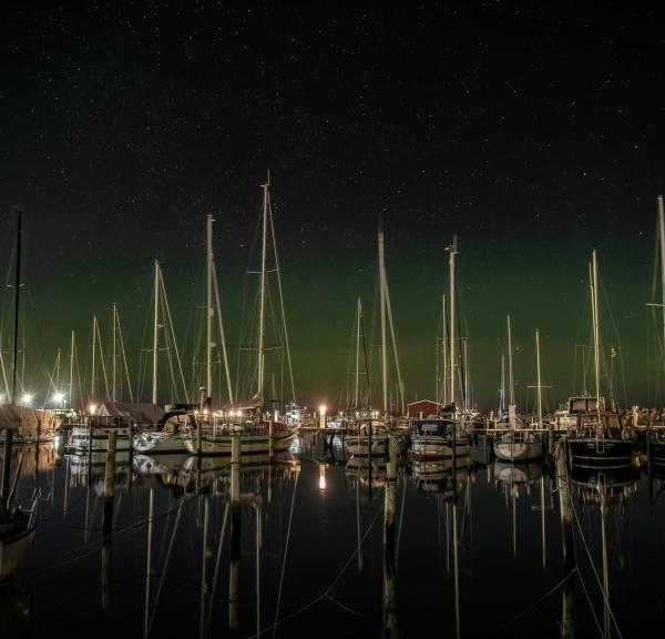 Både i vandet, med nordlys i baggrunden